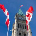 Tour de la paix du Parlement du Canada, entourée de drapeaux canadiens.